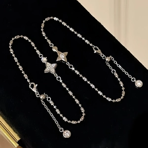 Detailed view of silver star pendants with sparkling zircons on fine beaded bracelets