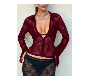 Detailed close-up of wine red lace fabric with intricate floral cutout patterns