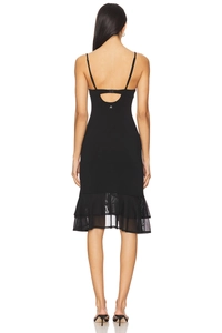Detail of slim black slip dress featuring a strappy open back and layered mesh ruffle hem