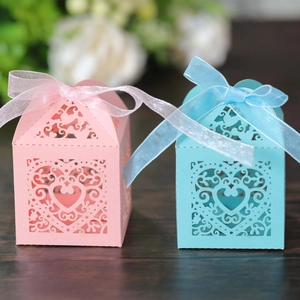 Detail of laser-cut heart candy boxes in pink and blue with elegant organza ribbons