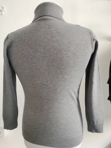 Detail view showing ribbed cuffs and hem of this grey turtleneck knit sweater