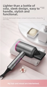 Sèche-cheveux ionique gris léger avec détails roses sur serviette de bain
