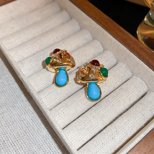 Detail of vintage mushroom earrings with colorful enamel and sparkling rhinestones