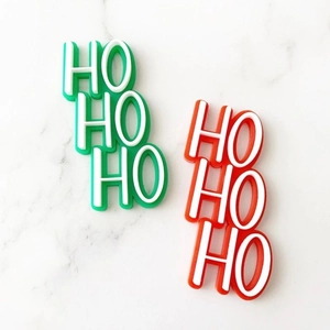 Macro detail of HO HO HO Christmas cake toppers in festive red and green acrylic