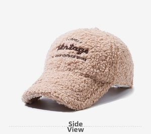 Dettaglio del ricamo vintage e della calda texture sherpa su questo cappellino beige