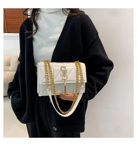 Detail of white quilted PU leather bag featuring a gold S-logo buckle and chain strap