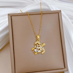 Luxurious gold turtle necklace with sparkling rhinestones on brown leather display