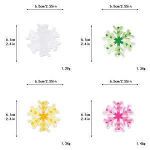 Macro detail of snowflake embroidery patches in white green yellow and pink colors