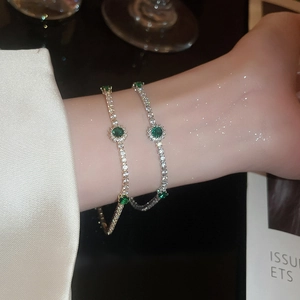 Vue détaillée des bracelets or et argent avec gemmes vertes et pavage de zircons fins