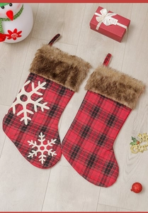 Détail de chaussettes de Noël à carreaux rouges et noirs avec revers en fausse fourrure brune