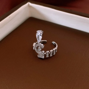 Macro shot of silver adjustable ring featuring a number 5 and pear-cut zircon stone
