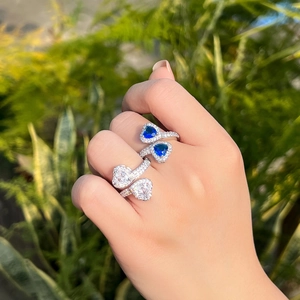 Elegant silver heart rings with blue sapphire and zircon stones on a woman's hand