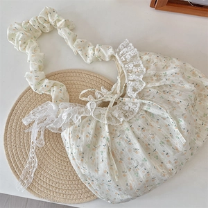 Détail du sac à fleurs avec bords en dentelle et bandoulière à volants sur tapis