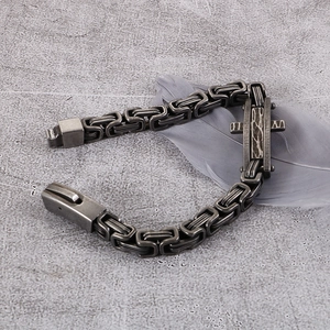 Macro detail of retro stainless steel cross bracelet with square link chain and clasp