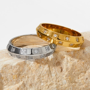Minimalist gold and silver stainless steel rings with clear zircons on textured stone