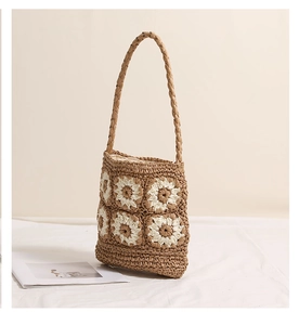 Close-up of handmade crochet daisy pattern and woven texture on a brown beach bag