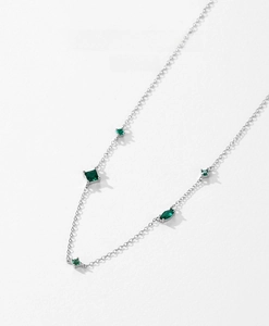 Macro detail of S925 silver chain necklace featuring emerald green zircon stones