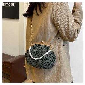 Detail of leopard print shell bag with pearl handle and golden metal clasp closure