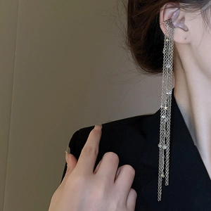 Macro detail of silver tassel ear cuff with sparkling stars and rhinestones on model