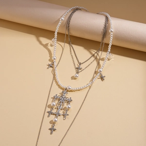 Elegant multi-layer pearl necklace with rhinestone cross pendants on a beige cylinder display