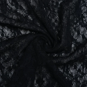 Macro shot of intricate black mesh lace fabric texture with elegant floral embroidery