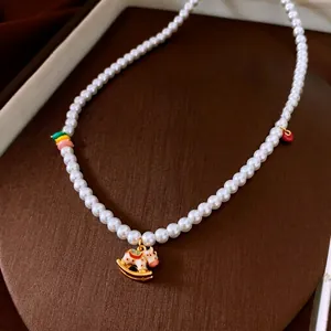 Collier de perles élégant avec pendentif cheval à bascule doré sur boîte à bijoux