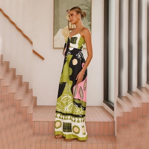 Detail of bohemian abstract plant print on a black V-neck jumpsuit with waist tie