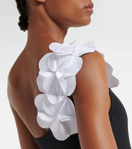 Detailed view of 3D white floral appliques on black one-shoulder swimsuit strap