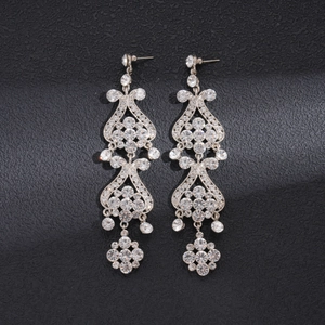 Macro shot of vintage silver flower tassel earrings with crystal rhinestones on black background