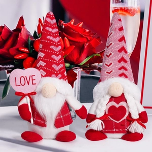 Close-up of Valentine's gnomes holding LOVE sign with roses and champagne background