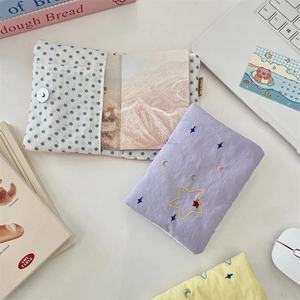 Close-up of embroidered star passport holders and organizers on a minimalist workspace desk