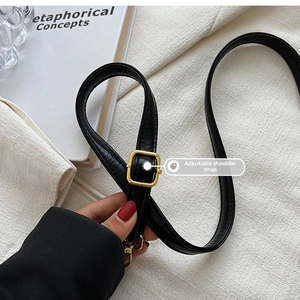 Detail of adjustable black leather strap with gold metal buckle for crossbody bags