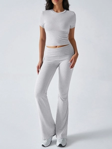 Full body shot of a grey two-piece set featuring short sleeve crop top and flared pants
