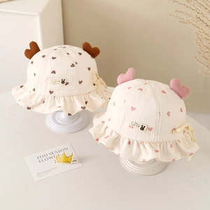 Detail of infant bucket hat with heart print, ruffled brim, and adjustable strap