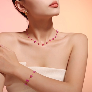 Detail of rose red natural gravel stones on gold chain necklace and bracelet set