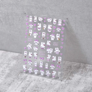 Gros plan de stickers 3D pour ongles avec de mignons lapins violets et cœurs