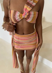 Detailaufnahme von pinkfarbenem Pailletten-Strickset mit Neckholder-Top und Minirock
