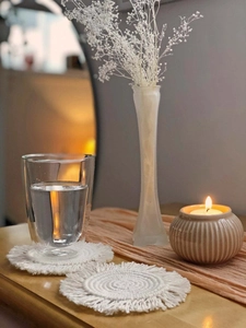 Detailed close-up of bohemian style woven coasters with fringe edges and cotton texture