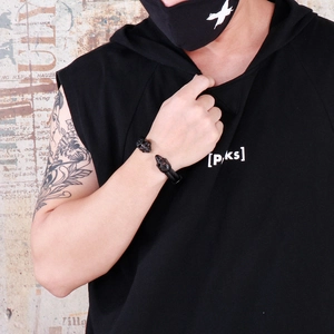 Close-up of punk black double skull cable bangle on male model in industrial style