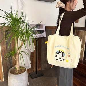 Close-up of cute dog embroidery and drawstring detail on off-white canvas tote bag