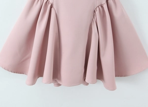 Detailed view of the wide pleated hem and stitching on a pink evening dress