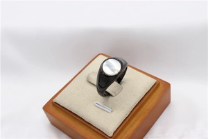 Detail of a black signet ring featuring a round iridescent white mother of pearl inlay