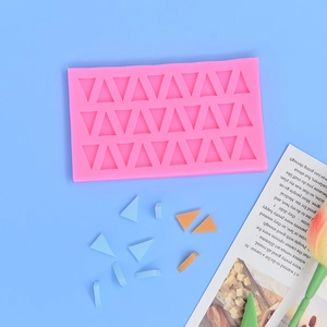 Pink silicone mold for triangle chocolate and soap making on a light blue background