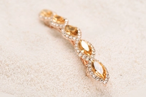 Macro shot of marquise yellow crystal hair clip with small rhinestones on rose gold base