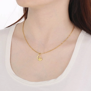 Close-up of 18K gold stainless steel necklace with sparkling moon and star pendant