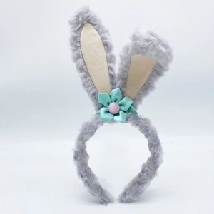 Detail of plush grey bunny ear headband with teal ribbon bow and pink button accent