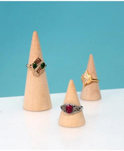 Macro view of gold and silver rings with gemstones on wooden cone display stands