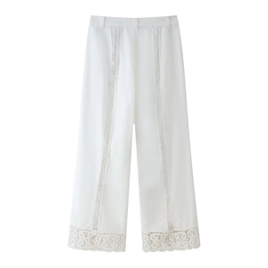 Détail d'un pantalon blanc large avec une finition en dentelle crochetée ajourée en bas