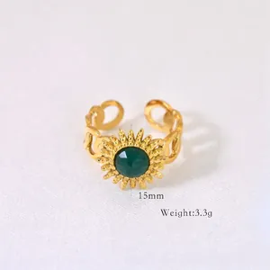 Detail view of sunflower-shaped ring with green stone and heart-shaped hollow band