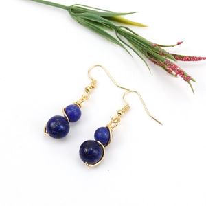 Detail of gold wire wrapped dark blue lapis lazuli beaded drop earrings with ear hooks